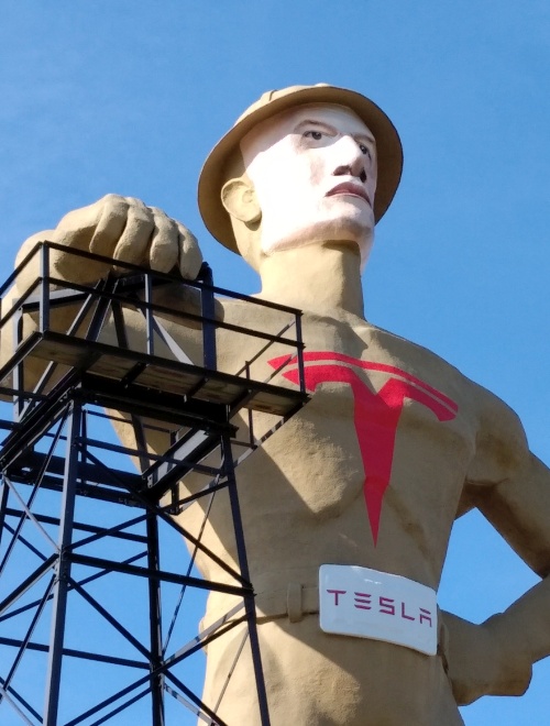Tulsa's Golden Driller remade with the Tesla logo and with a face mask resembling Elon Musk