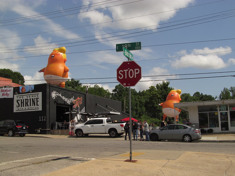 Two Trump Baby Balloons float over The Venue Shrine, 18th and Boston, in Tulsa
